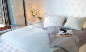 Una cama con dos tazas y una bandeja. en Villa del Alemán by Rental Olé, en Lo Mendigo