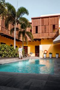 a woman is sitting next to a swimming pool at Ponce Plaza Hotel & Casino in Ponce