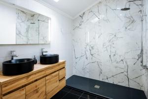 a bathroom with two sinks and a marble wall at Santa Clara Lisbon Rooms in Lisbon