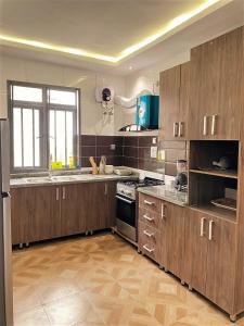 a large kitchen with wooden cabinets and a window at 3 Bedroom Luxury Apartment in Lekki in Lagos