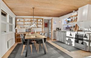 eine Küche mit einer Holzdecke sowie einem Tisch und Stühlen in der Unterkunft Amazing Home In Skagen With Wifi in Skagen