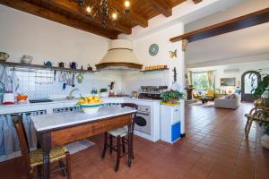 a kitchen with white counters and a table in a room at Villa Tina in Taormina