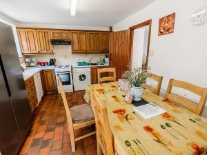 a kitchen with a table and a kitchen with a refrigerator at Cedar Cottage - Rchp132 in Calton