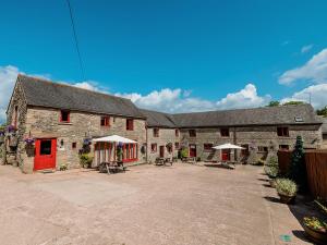 a large stone building with a red door at Cedar Cottage - Rchp132 in Calton