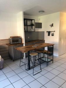 a kitchen with a wooden table and stools at Moriani Les Marines de Moriani Plage in San-Nicolao