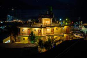 um edifício com uma placa no topo à noite em Hotel Kaavi em Pokhara