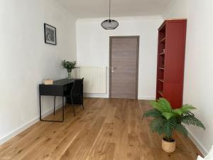 uma sala de estar vazia com uma secretária e uma planta em FDS Cosy House em Gent