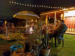 un groupe de personnes assises à une table la nuit dans l'établissement Casa entera - La Campiña Suiza TABIO TENJO, à Tenjo