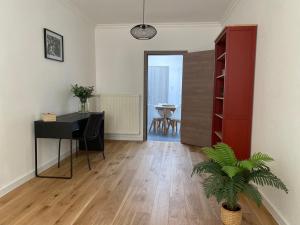 uma sala de estar com uma secretária e uma mesa com uma planta em FDS Cosy House em Gent