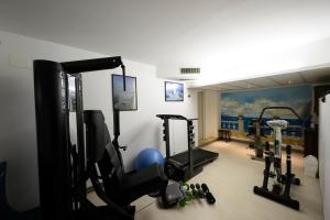 a room with a gym with several tread machines at Hotel Riviera in Riva del Garda