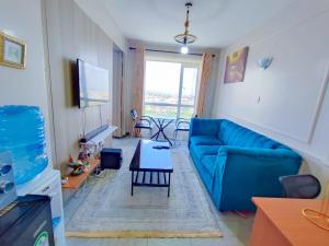 a living room with a blue couch and a table at Crystal Spheres in Nairobi