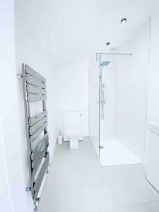 een witte badkamer met een douche en een toilet bij Exclusive 4-Bed House 10 minutes from Newcastle in Ravensworth