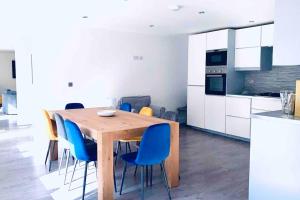 a kitchen with a wooden table and blue chairs at Exclusive 4-Bed House 10 minutes from Newcastle in Ravensworth
