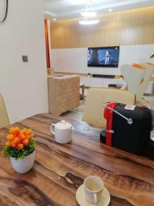 a room with a table with a suitcase and flowers on it at Beautiful 2 bedroom in Ologolo in Lekki