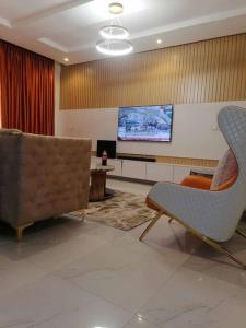 a living room with a couch and a tv at Beautiful 2 bedroom in Ologolo in Lekki