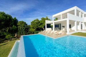 une villa avec piscine devant une maison dans l'établissement Casa Laila - acceso directo al mar, piscina y wifi, à Portopetro