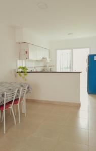 cocina blanca con mesa y barra en Depto Duplex en Tandil