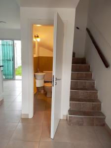 pasillo con escalera, aseo y baño en Depto Duplex en Tandil