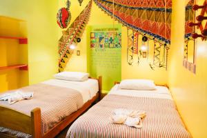 - 2 lits dans une chambre aux murs jaunes dans l'établissement Backpacker La Bo'M, à Cusco
