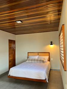 a bedroom with a bed with a wooden ceiling at Lyttos Bungalows in Icapuí