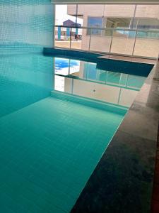 a swimming pool with a reflection in the water at Temporada Cabo Frio - Braga in Cabo Frio