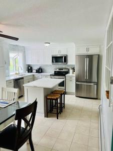 una cocina con armarios blancos y electrodomésticos de acero inoxidable en Hadley Amherst Location Explore Pioneer Valley, en Hadley