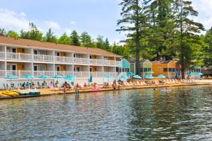 a resort on the water with people on the beach at NASWA Resort in Laconia