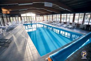 una gran piscina con sillas en un edificio en Hotel Ravni Gaj, en Knić