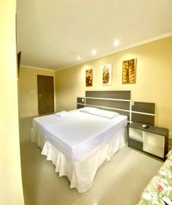 a bedroom with a large white bed in a room at HANNA Arcos d'Atalaia Hotel - Aracaju in Aracaju