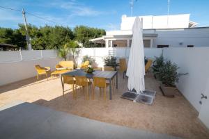 a patio with a table and an umbrella and chairs at VILLA LEVANTE - Beach & Jacuzzi in Torre Santa Sabina