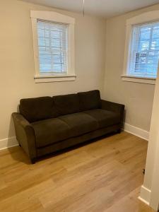 a brown couch in a room with two windows at Lincoln Park Aparment with Backyard! in Chicago