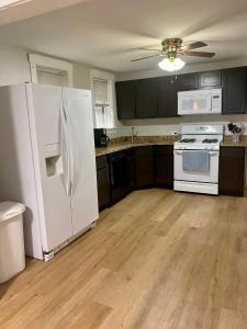 a kitchen with a white refrigerator and wooden floors at Lincoln Park Aparment with Backyard! in Chicago