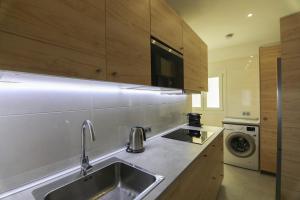 a kitchen with a sink and a washing machine at RentalSevilla Moderno apartamento en Triana de 95m2 in Seville