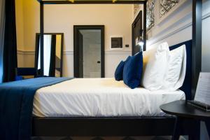 a bedroom with a bed with blue and white pillows at Roma Luxus Hotel in Rome
