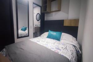 Un dormitorio con una cama con una almohada azul. en Ayenda Gold House, en Bogotá