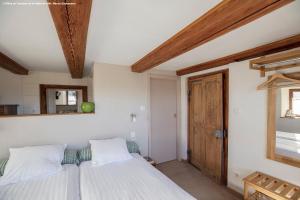 a bedroom with a bed and a wooden ceiling at A l'ombre du verger in Breitenau