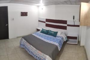 1 dormitorio con 1 cama con 2 almohadas en Ayenda Gold House, en Bogotá