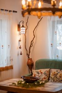 ein Wohnzimmer mit einem Tisch und einer Lampe in der Unterkunft Casa cu Cerdac in Nucşoara
