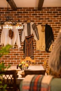 a room with clothes hanging on a brick wall at Casa cu Cerdac in Nucşoara