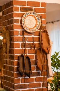 eine Platte und Schuhe, die an einer Ziegelmauer hängen in der Unterkunft Casa cu Cerdac in Nucşoara