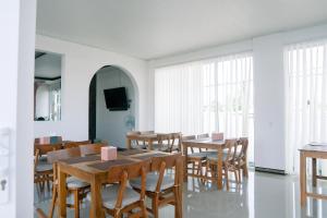 uma sala de jantar com mesas e cadeiras de madeira em Christika Homestay em Labuan Bajo