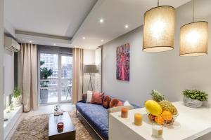 a living room with a blue couch and a table at Lumina apartments with awesome view near Warsaw Uprising Museum in Warsaw