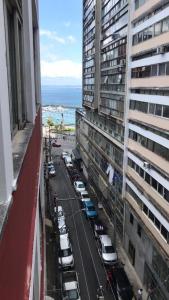 widok na ulicę miejską z zaparkowanymi samochodami i ocean w obiekcie Apartamento no Centro Histórico de Salvador w mieście Salvador
