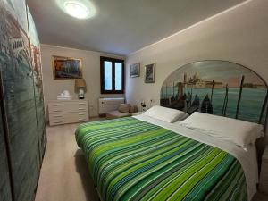 una camera da letto con un grande letto con una coperta a righe colorate di Grimaldi Apartments San Marco & Castello a Venezia