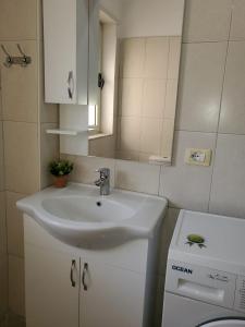 een badkamer met een wastafel, een toilet en een spiegel bij Standart apartment in Durrës