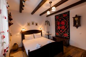 a bedroom with a bed and a painting on the wall at Casa cu Cerdac in Nucşoara