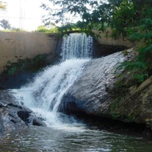 a waterfall on the side of a river at Pousada Rural e Pesqueiro Chalé da serra in Conceição da Ibitipoca