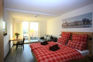 um quarto com uma cama com um cobertor xadrez vermelho em Überlinger See-Apartments Über-See Apartment 3 em Überlingen