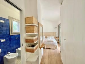 Un baño con lavabo y una cama en una habitación. en DOMUS MARIS Villa Charmant Porto Giunco Notteri VILLASIMIUS, en Notteri 40 fotos más