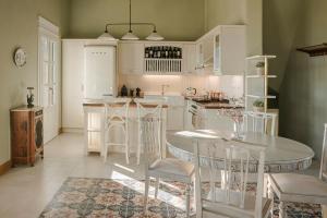 a kitchen with white cabinets and a table and chairs at Villa Comi in Mavráta